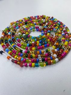 Brighten your life and wardrobe with our stunning Multicolored Waistbead. Handcrafted with love, each bead is carefully selected and strung to create a vibrant, eye-catching accessory that complements any outfit. Uses of the Multicolored Waistbead: • Fashion Statement: Wear it over or under your clothing to add a pop of color and a touch of elegance to your ensemble. • Body Awareness: Helps you stay mindful of your body, serving as a gentle reminder of your fitness and wellness journey. • Weight Multicolor Beaded Chain Waist Beads For Festivals, Multicolor Round Waist Beads For Beach, Multicolor Waist Beads For The Beach, Multicolor Waist Beads For Beach, Large Multicolor Beads For Beach, Bohemian Round Beads For Party, Bohemian Rainbow Heart Beads, Multicolor Beaded Chain For Festival, Multicolor Heart Beads Round Jewelry