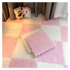 a teddy bear sitting next to a pink and white rug