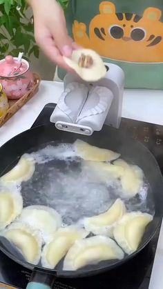 a person is frying ravioli in a pan on the stove