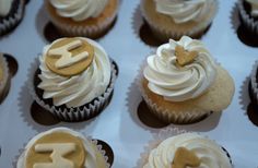 cupcakes with white frosting and gold decorations