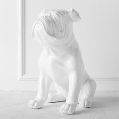 a white dog statue sitting on top of a floor