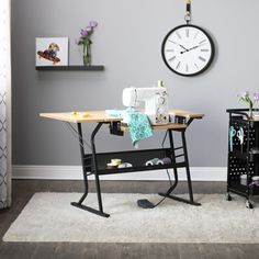 a living room with a clock on the wall next to a table and chair in front of it