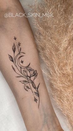 a woman's leg with a flower tattoo on the left side of her arm