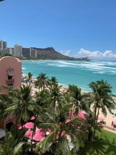 the beach is lined with palm trees and umbrellas in front of an ocean view