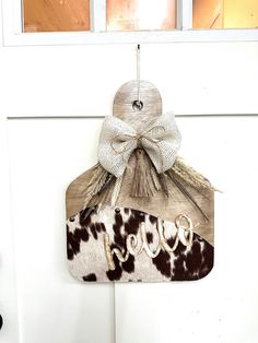 a cow print door hanger with the word boo written on it and a bow