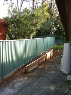 the fence is made out of metal and has plants growing in it, along with some wood pallets