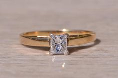 a gold ring with a princess cut diamond