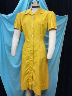 "1940s W:32 Coronet vintage uniform dress sanforized cotton pockets mustard yellow short sleeve button up collared V neck button A-line  Great 40s uniform dress from Coronet, Los Angeles. Aline silhouette of paneled construction with placket. Two side pockets. Fitted bodice with white buttons, opening all the way. Dense cotton weave in amazing shade of vintage mustard yellow. Puffed sleeves, collared V neckline.  Photographed on fitting form size 2, check measurements, vintage size labeled 36. M Yellow Button-up Cotton Dress, Yellow Cotton Button-up Dress, Solid Color Vintage Cotton Dress, 1950s Style Vintage Short Sleeve Dress For Work, Vintage Cotton Workwear Dresses, Vintage Cotton Dresses For Work, Vintage Yellow Short Sleeve Dress, Yellow Cotton Retro Vintage Dress, Cotton Vintage Dress With Short Sleeves