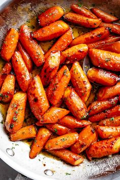 cooked carrots in a skillet with a wooden spoon