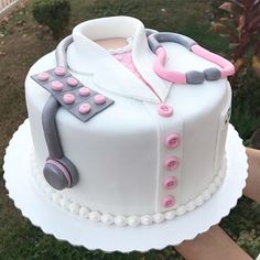 a white cake with pink and grey decorations