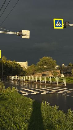 an intersection with traffic lights and street signs in the background under a dark cloudy sky