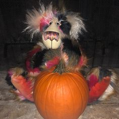 a stuffed animal sitting next to a pumpkin