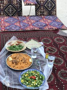 a table topped with plates of food on top of a rug