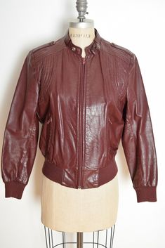 huncamuncavintage Description: This is an awesome vintage motorcycle jacket from the 80s. It's made of genuine leather (fully lined) that's cherry-brown in color. This jacket has quilted shoulders, two pockets, epaulets, sweater cuffs and waistband, and it closes up the front with a breakaway zipper. PLEASE NOTE: There are two tiny knicks on the back. Label: Berman's **Colors in real life may vary a little from the pictures, due to lighting and monitor differences**   Measurements: This jacket f Vintage Motorcycle Jacket, Cherry Brown, 80s Jacket, Vintage Motorcycle, The 80s, Vibrant Red, Motorcycle Jacket, Stranger Things, Real Life