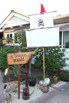 a sign with a pirate hat on it in front of a house that says ye taurus beware