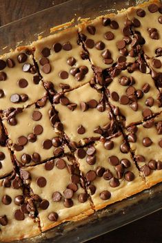 chocolate chip cookie bars with peanut butter frosting in a glass baking dish on a wooden table