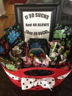 a basket filled with candy and candies next to a sign that reads it's 30 sucks and 40 blows