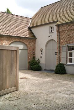 a large brick house with two garage doors