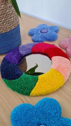 colorful rugs are arranged on the floor next to a potted plant and mirror