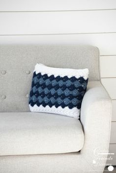 a blue and white pillow sitting on top of a couch