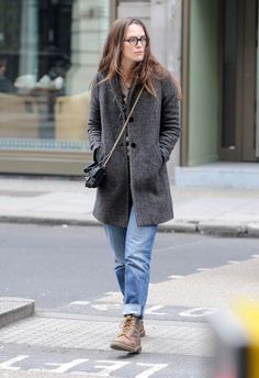 a woman walking down the street with her hand in her pocket