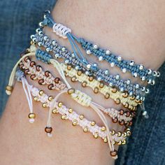 a close up of a person's arm wearing bracelets with beads on them