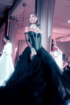 Embrace the drama in this black ball gown extravaganza. A symphony of elegance unfolds as a dramatic, pearl-studded boned sheer corset takes center stage, adorned with opulence. The corset's intricate design is paired with an opulent black tulle skirt, creating an ethereal dance of textures. Glamorous Boned Bodice Corset Dress For Debutante Ball, Black Evening Gown With Boned Bodice, Black Gown With Boned Bodice For Evening, Black Corset Dress With Boned Bodice For Gala, Luxury Black Gown With Sheer Bodice, Black Gala Gown With Boned Bodice, Black Gown With Boned Bodice For Gala, Black Wedding Ball Gown With Boned Bodice, Elegant Overbust Ball Gown For Prom