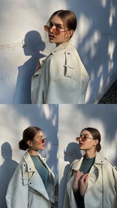 a woman wearing glasses and a trench coat is standing in front of a white wall