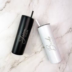 two black and white tumblers sitting on top of a marble counter