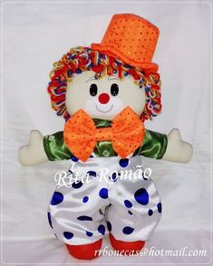 a stuffed toy with an orange top hat and polka dots on it's pants