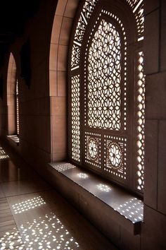 the sun shines through an arched window in a building