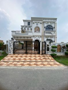 a large white and brown house sitting on top of a lush green field