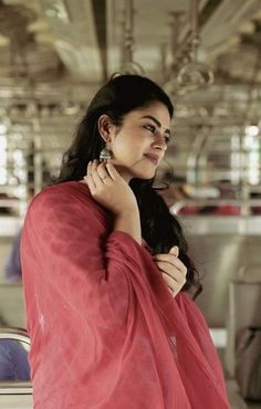 a woman in a red sari is posing for the camera