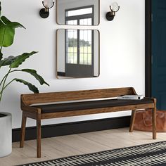 a wooden bench sitting next to a potted plant in front of a wall mounted mirror