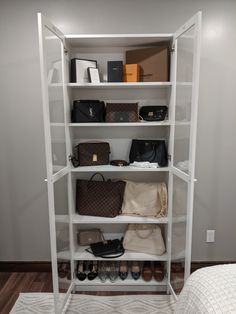 a white shelf filled with lots of purses and handbags