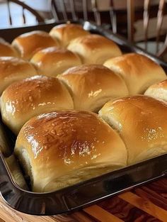 a pan filled with rolls sitting on top of a wooden table