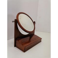 an old fashioned wooden mirror on a stand