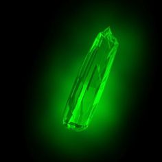 a bright green diamond is glowing in the dark, with only one light on it's side