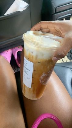 a woman holding a cup of iced coffee