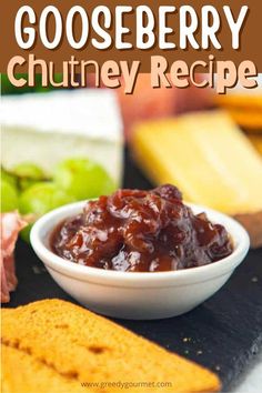 a bowl filled with cranberry chutney next to crackers