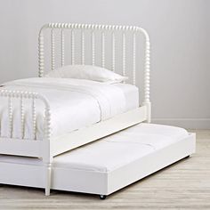 a white bed sitting on top of a wooden floor