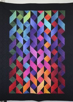 a black quilt with multicolored squares on it