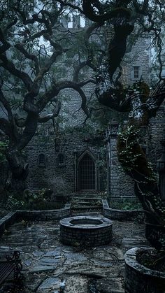 an old stone building surrounded by trees in the rain