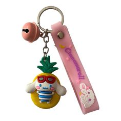 a keychain with a pineapple on it next to a pink eraser