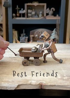 a person is pulling a toy dog in a cart on a wooden table with the words best friends