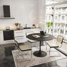 a kitchen area with a table, chairs and an oven in the backround