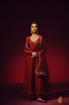 "A classic maroon full-sleeved\u00a0anarkali\u00a0with an\u00a0angrakha style neckline, punctuated with aari embroidery on the bodice, sleeves, and a shower of floral bootis\u00a0on the flared ends. Paired with a plain churidar\u00a0and an ornately hand-embroidered organza dupatta.\n\n\n\n Color\u00a0-  A\u00a0rich shade of\u00a0Maroon\n\n\n Fabric\u00a0-\u00a0Anarkali in pure Chanderi\u00a0silk, churidar in\u00a0pure silk, dupatta in pure organza silk\n\n\nCollection Note\u00a0-\u00a0Distinguished by its creative\u00a0rendition of designs that\u00a0reflect a heritage steeped in artistry, the Tilfi Kala collection draws inspiration from the\u00a0mesmerising\u00a0intricacy\u00a0of old Mughal miniature art and architecture, bringing\u00a0it to life on textiles through masterful craftsmanship Banarasi Anarkali, Maroon Anarkali, Angrakha Anarkali, Mughal Miniature, Anarkali Designs, Kurti Cotton, Kurta Women, Shades Of Maroon, Women Kurti