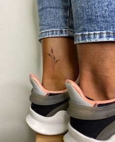 a woman's foot with a small tattoo on her left ankle and right leg