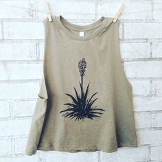 "This trendy tank is Screenprinted by me with my own art. This shirt has my Yucca Plant Design on it, New Mexico's state flower! Key Features: -preshrunk 50% polyester/25% cotton/25% rayon jersey -4.3-oz. -32 singles for extreme softness -front cover-stitched 1x1 baby rib-knit set-in collar ---Please let me help YOU choose the right size!--- EVERY CLOTHING BRAND RUNS SLIGHTLY DIFFERENTLY SO IT IS ESSENTIAL TO UTILIZE MEASUREMENTS WHEN ORDERING CLOTHING ONLINE TO DETERMINE THE CORRECT SIZE. Measu Sleeveless Screen Print Tank Top For Spring, Embroidered Tank Top For Festivals, Yucca Plant Tattoo New Mexico, Summer Screen Print Muscle Tank Tee, Bohemian Graphic Print Tank Top For Festivals, Bohemian Cotton Tank Top With Graphic Print, Bohemian Summer T-shirt With Plant Print, Cactus Tshirt Inspire Uplift ⭐, Yucca Plant