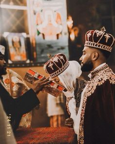 two men dressed in medieval clothing one is holding a book and the other is wearing a crown